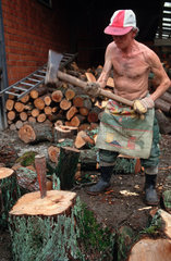 Essen  Knecht auf einem Bauernhof hackt Holz
