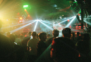Besucher eines Clubs in farbigem Scheinwerferlicht