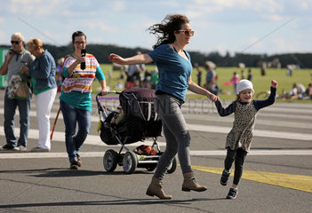 Berlin  Deutschland  Mutter springt froehlich mit ihrer Tochter auf dem Tempelhofer Feld herum