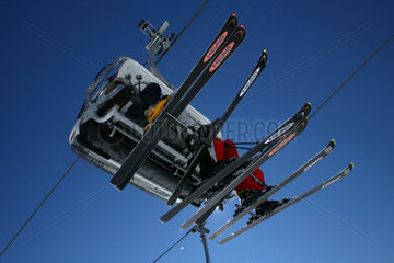 Skifahrer sitzen hoch oben in einer Seilbahn
