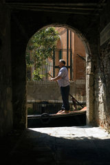Venedig  Italien  Gondelfuehrer vor einem Torbogen