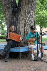 Las Vegas  USA  zwei Maenner sitzen unter einem Baum im Park und machen Musik