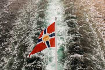 Eine norwegische Flagge weht am Heck eines Postschiffes (Norwegen)