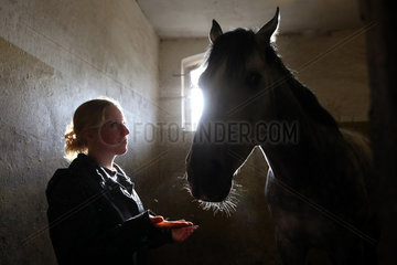Neuenhagen  Deutschland  Silhouette  Frau und Pferd in einer Pferdebox