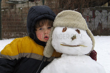 Ein Kind hat einen Schneemann gebaut