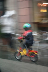 Berlin  Kleines Kind mit Helm auf Kinderfahrrad