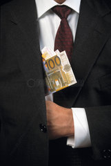 Eurogeldscheine werden in die Jackentasche eines Anzuges versteckt