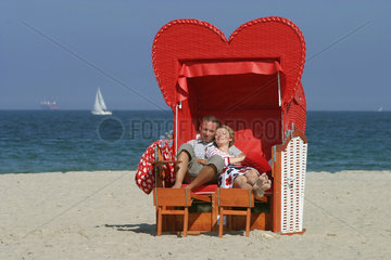 Luebeck-Travemuende  Verliebtes Paar im Herzstrandkorb