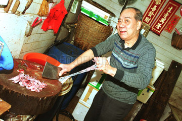 Chinese beim Haeuten von Froeschen in Hongkong
