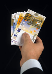 Eurogeldscheine in der Hand eines Mannes im Anzug