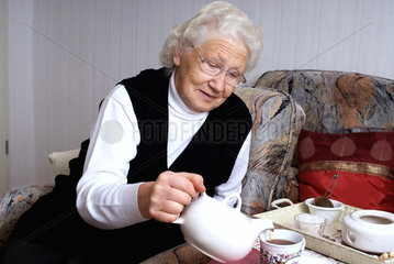Nauen  Deutschland  eine Rentnerin giesst sich Tee ein