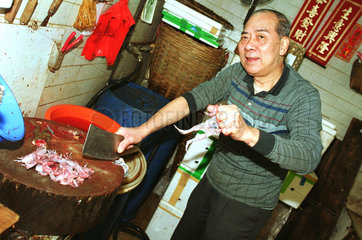 Chinese beim Haeuten von Froeschen in Hongkong