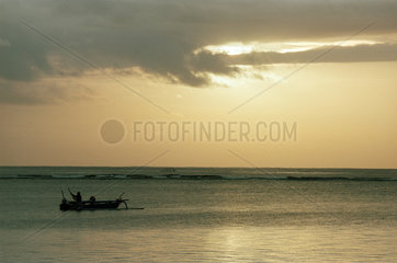 Morgendliche Stimmung nach dem Sonnenaufgang am Meer auf Bali mit Fischerboot