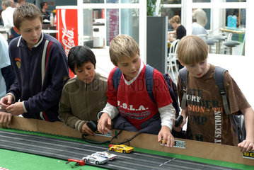Kinder spielen mit einer Rennbahn