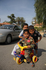 Nikosia  Tuerkische Republik Nordzypern  ein Junge in Militaerkleidung auf einem Dreirad mit seinen Freunden