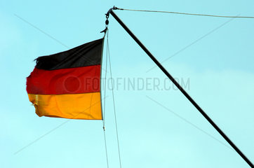 Wehende  zerrissene Deutschlandfahne im Wind