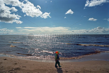 Ein Kind geht den Strand vom Peipsi See entlang  Estland