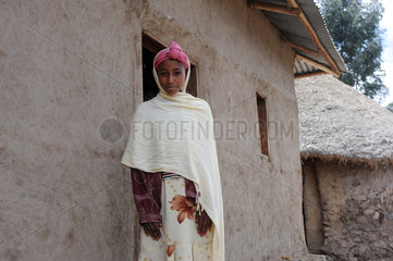 Mangudo  Aethiopien  Portraet einer jungen Afrikanerin vor ihrem Haus