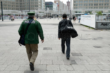 Berlin  Deutschland  ein Polizeibeamter und ein Mann mit Sporttasche