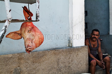 Santiago de Cuba  Kuba  ein Schweinekopf haengt am Haken