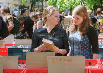 Zwei junge Frauen beim Buecherkauf auf dem Flohmarkt.