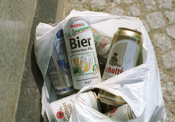 Bierdosen verschiedener Marken in einer Abfalltuete.