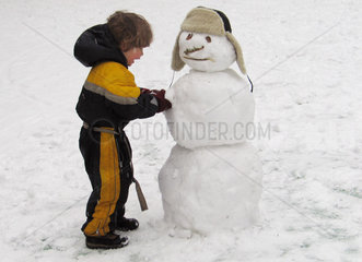 Ein Kind baut einen Schneemann