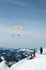 Oberstdorf  Deutschland  Paragleiter und Skifahrer in den Allgaeuer Alpen
