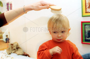 Einem Jungen werden die Haare gekaemmt