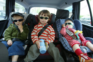 Berlin  drei Kinder angeschnallt in ihren Kindersitzen im Auto