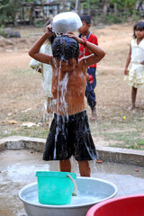 Phum Chikha  Kambodscha  ein Maedchen waescht sich am Dorfbrunnen