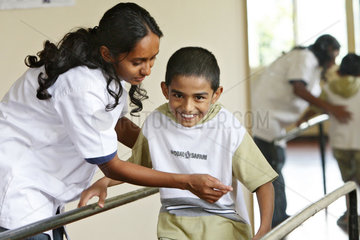 Kundasale  Sri Lanka  Junge uebt an einem Barren das Gehen