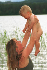 Mutter und Kind an einem See in Schweden