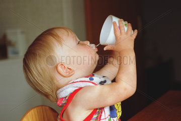 Ein Kleinkind trinkt aus einer Tasse