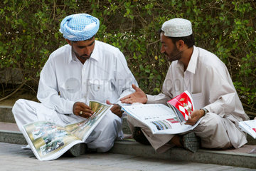 Maenner lesen Zeitung  Dubai