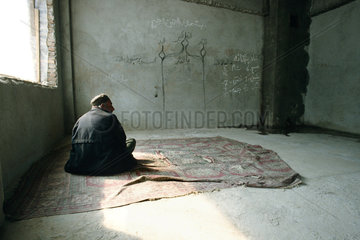 Fluechtling beim Beten in einer improvisierten Moschee.