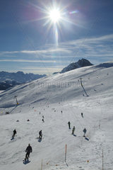 Skifahrer im Sonnenlicht auf der Piste des Gipfels Nair