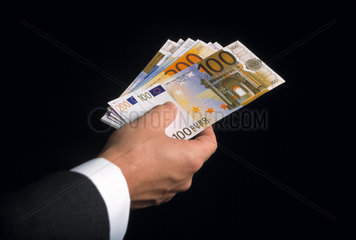 Eurogeldscheine in der Hand eines Mannes im Anzug