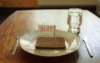 Ein Hinweisschild und eine Scheibe Brot auf einem Teller.