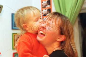 Ein Junge kuesst seine Mutter