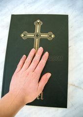 Eine Hand schwoert auf die Bibel