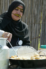 Eine verschleierte Frau beim Kochen  Dubai