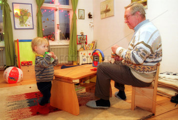 Grossvater spielt mit dem Enkel im Kinderzimmer