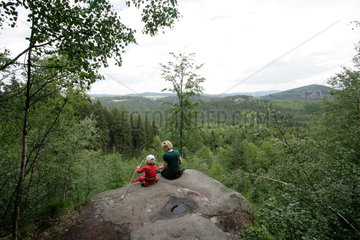 Hohnstein  Deutschland  eine Mutter sitzt mit ihrer Tochter auf einem Felsvorsprung