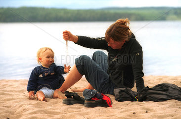 Mutter und Kind an einem See in Schweden