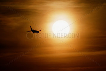 Flugzeug im Landeanflug im Sonnenuntergang