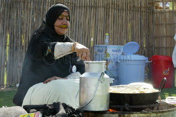 Eine verschleierte Frau beim Kochen  Dubai