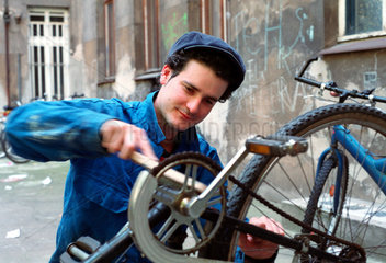 Ein junger Mann repariert sein Rad