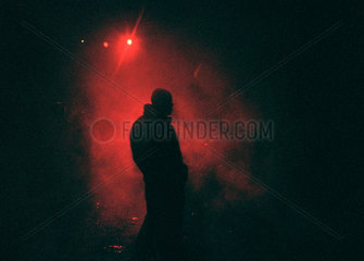 Mann in rotem Scheinwerferlicht bei einem Open Air Rave  Gross Doelln  Deutschland