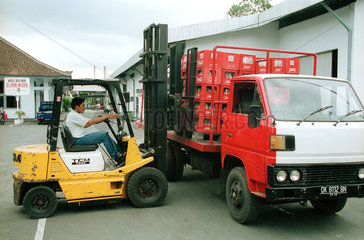 Beladen eines Transporters mit Kisten der Marke Coca-Cola auf Bali